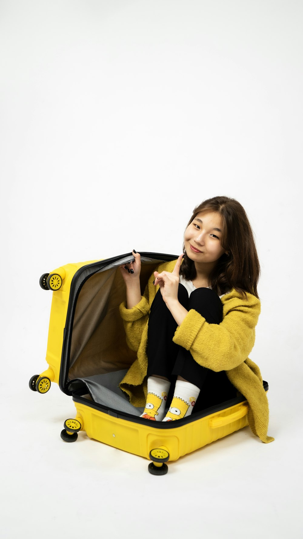 a person sitting in a yellow suitcase