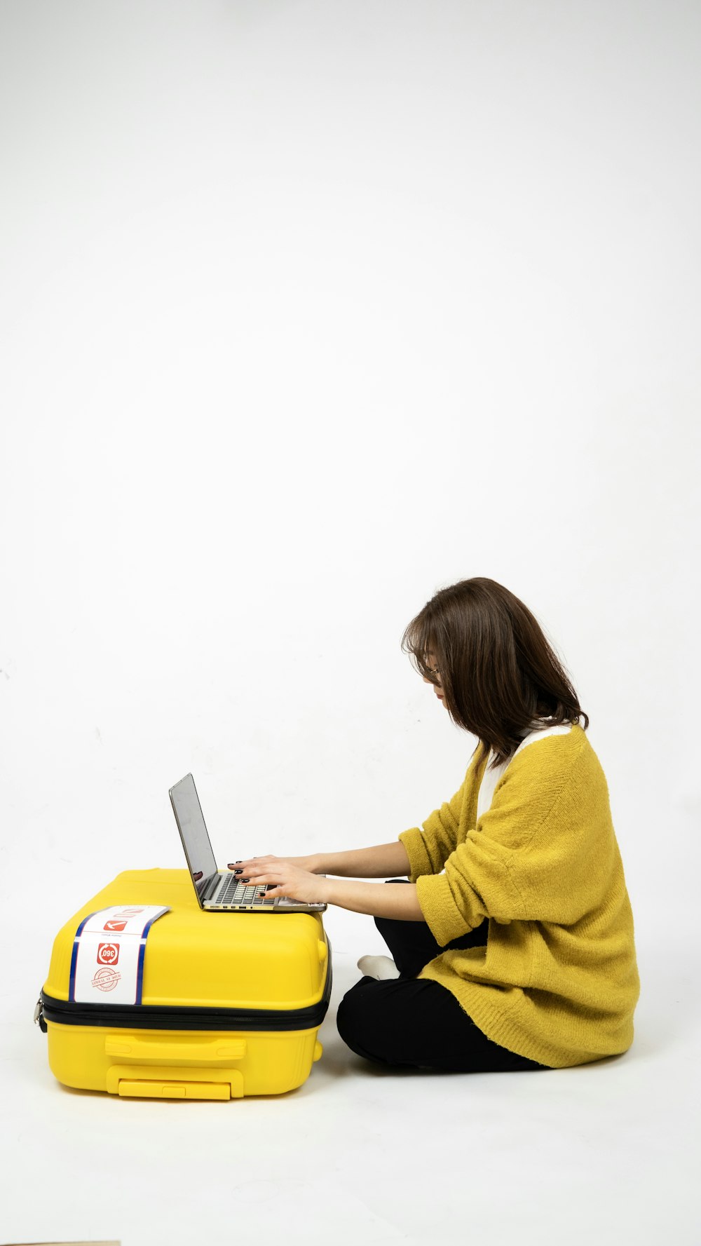 a person sitting on the floor using a laptop