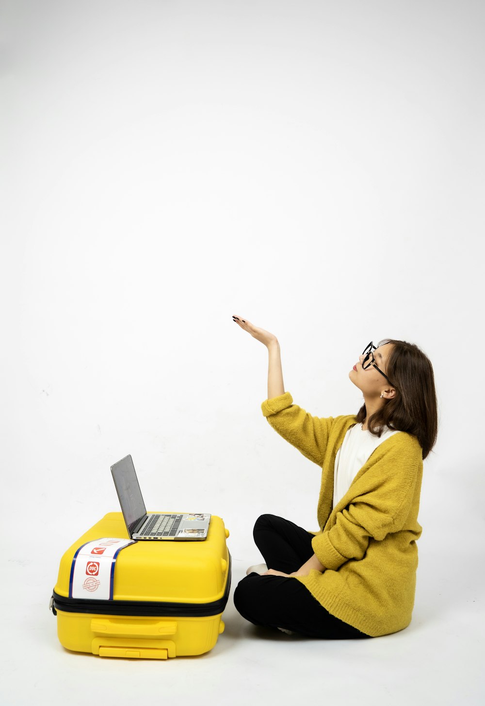 a person sitting on a yellow suitcase