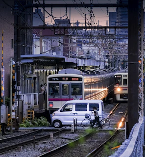 a person riding a bicycle next to a couple of trains on the tracks