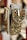 Ornate handbags adorned with colorful gemstones and intricate embroidery hang side by side. The bags feature a combination of red, green, and white stones set against a richly textured fabric. Gold chains and detailing enhance the luxurious appearance.