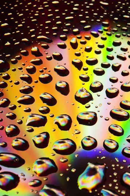 A vibrant palette of rain galore shades arranged artfully on a wet glass surface, droplets catching the light.