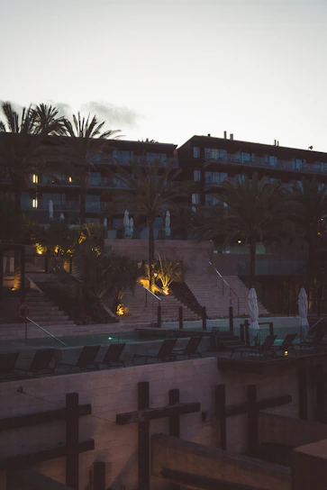 A serene villa exterior at sunset with soft pale purple lighting highlighting the tropical landscaping.