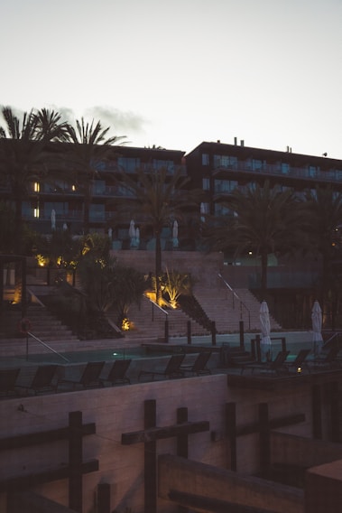 A serene villa patio overlooking lush tropical gardens with warm ambient lighting at dusk.