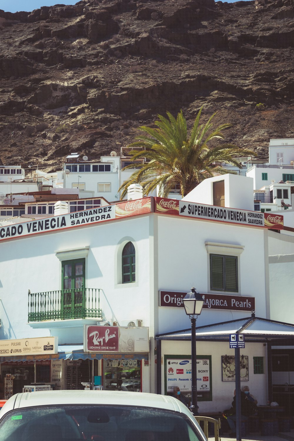 a white building with a hill in the background