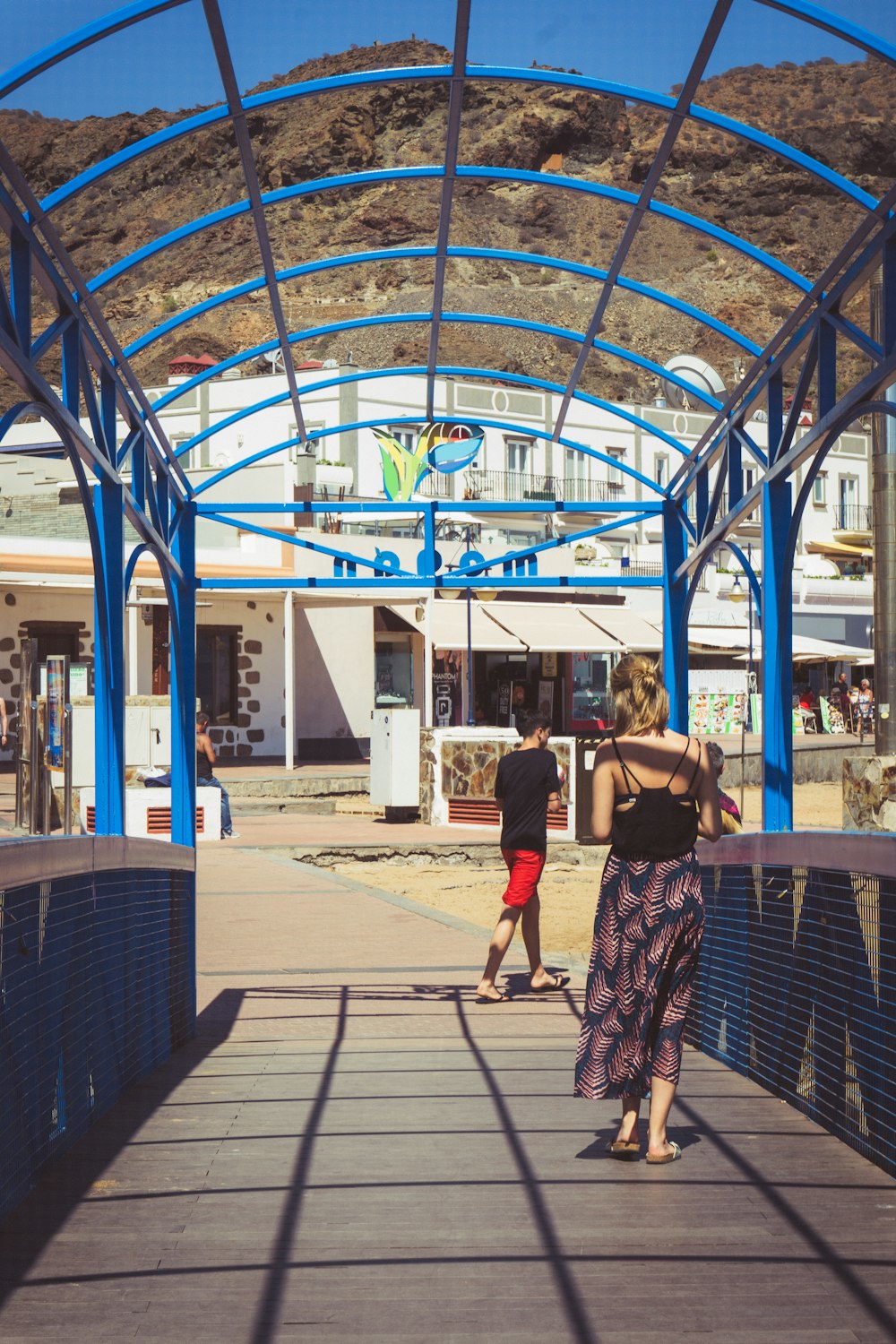 a couple of people walking on a bridge