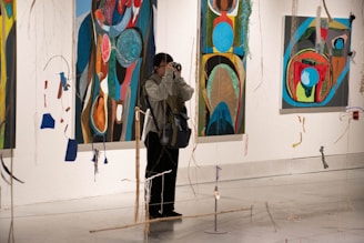 a person taking a picture of paintings