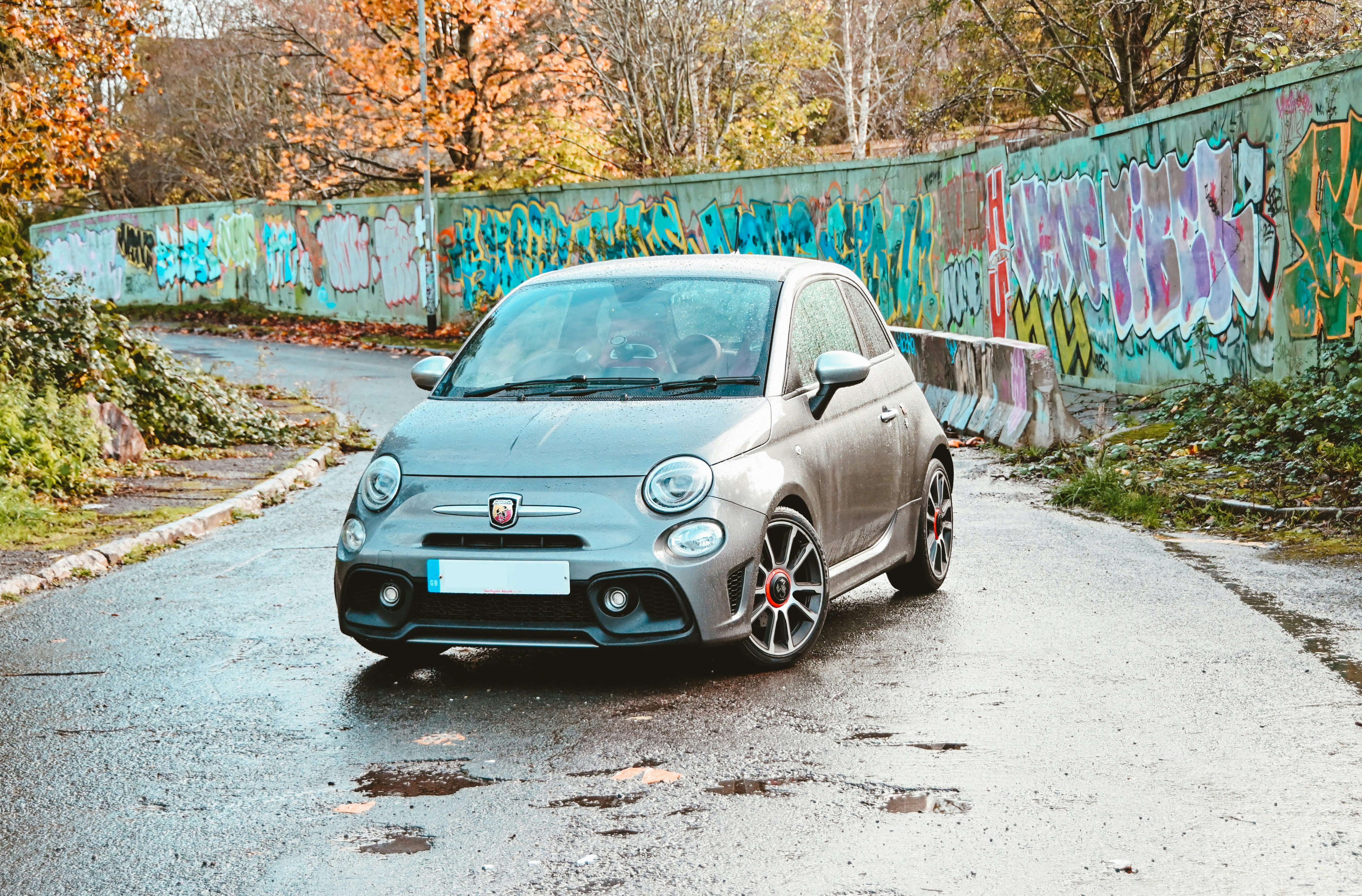 a car parked on a road with graffiti on the side