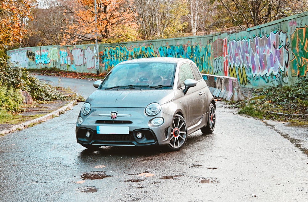 a car parked on a road with graffiti on the side