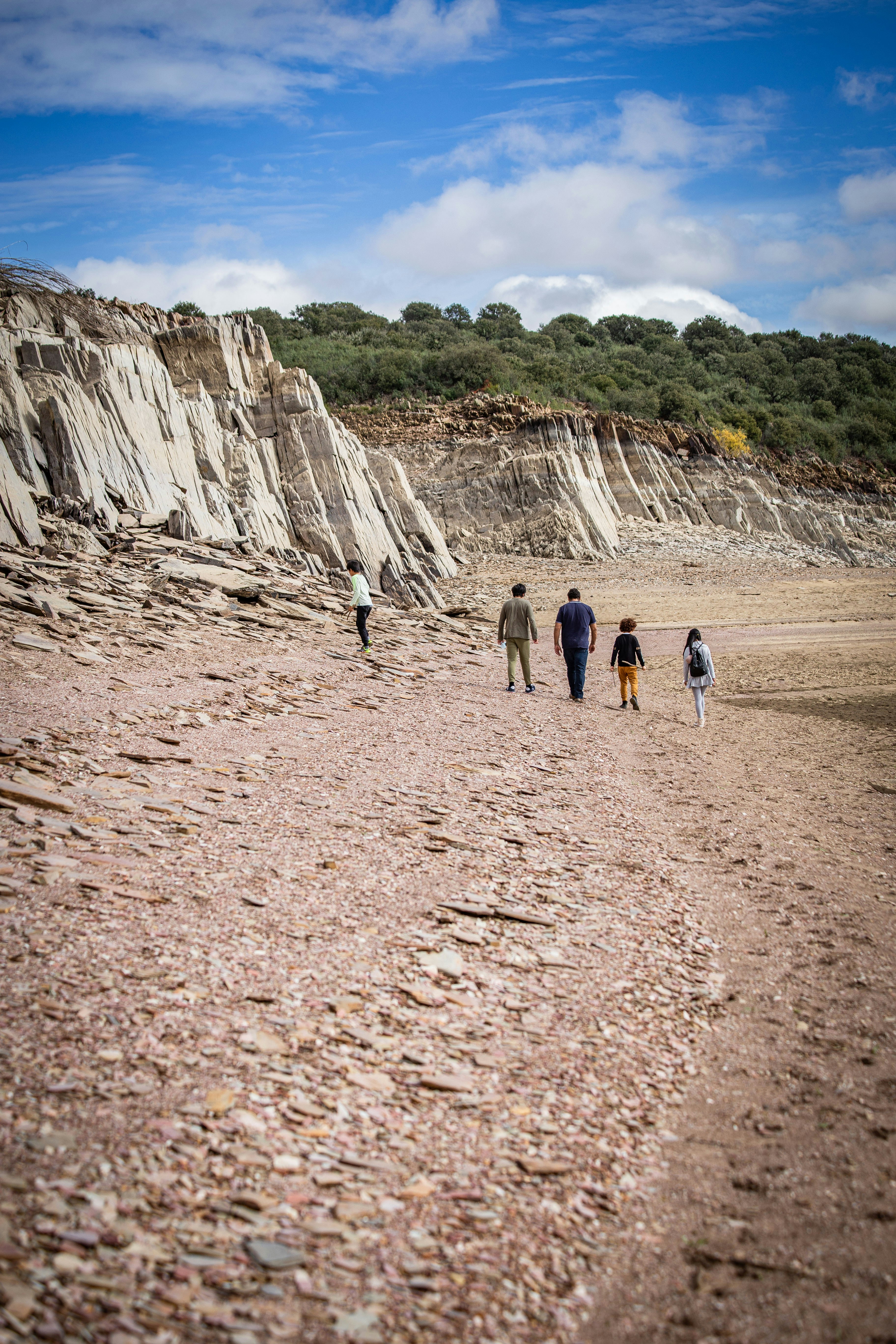 a group of people walking on a rocky beach