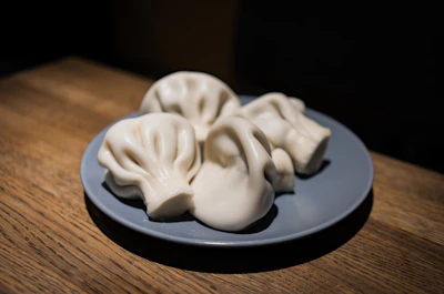 Close-up of perfectly cooked momos arranged on a rustic wooden platter.