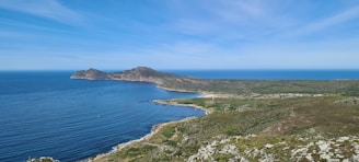A panoramic view of a pristine coastline where land meets the vibrant sea.