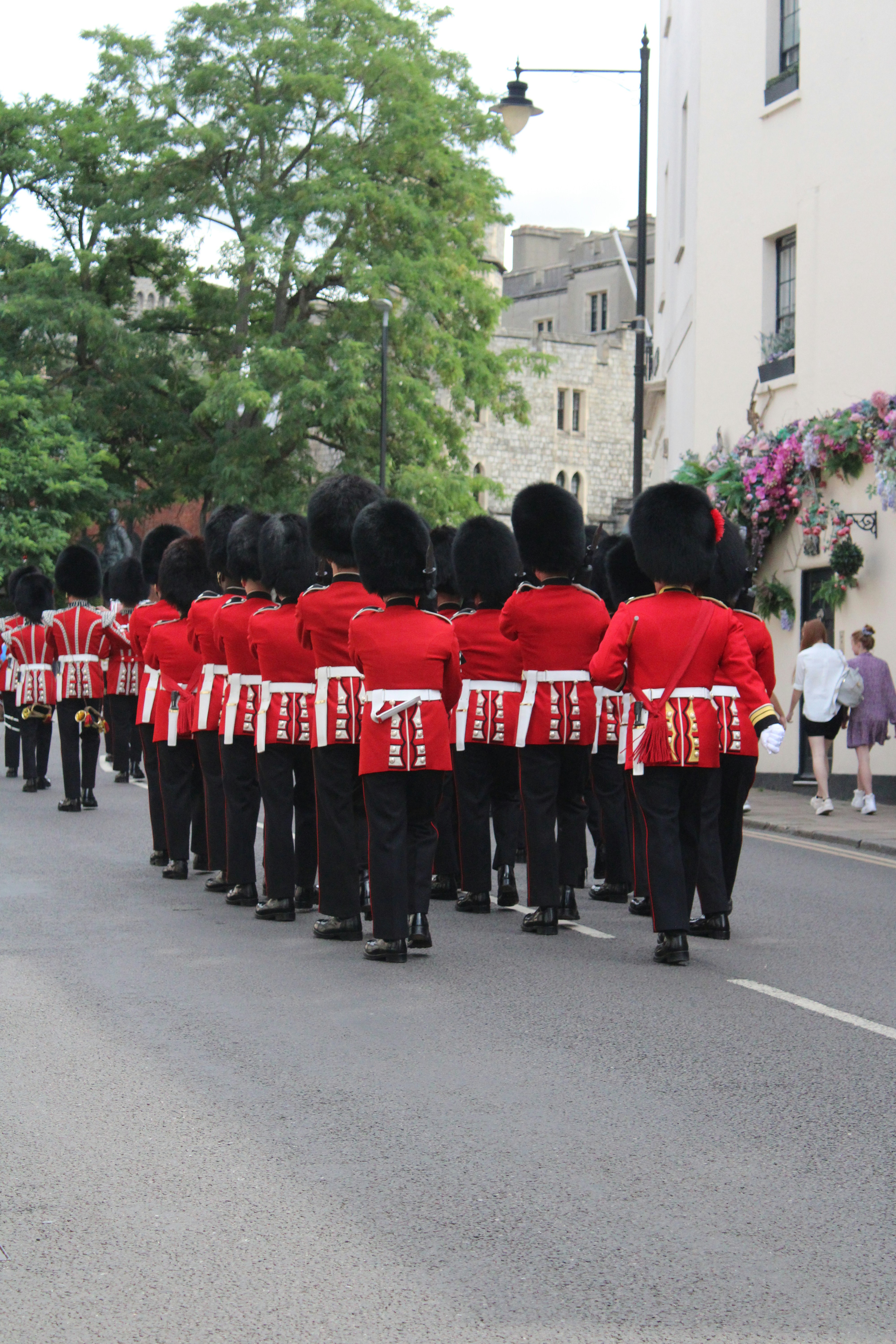 a group of people in red uniforms marching down a street