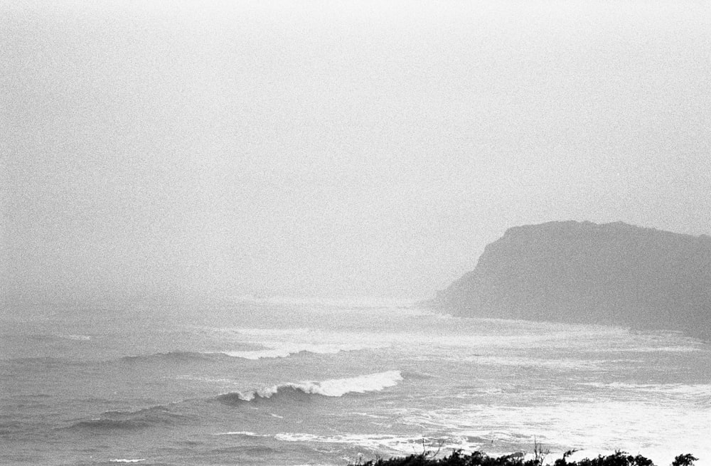 a body of water with a hill in the distance