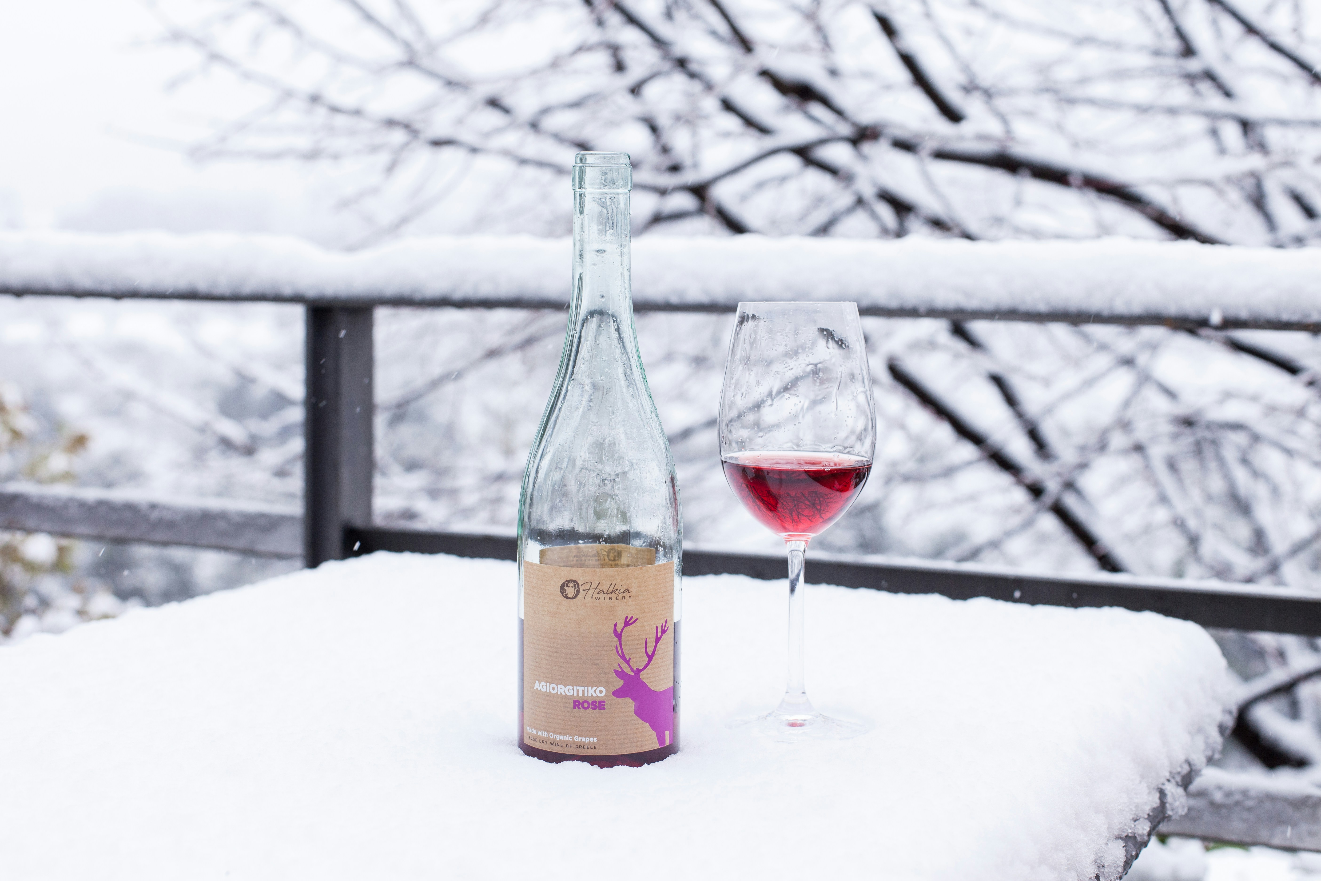 eine Flasche Wein und ein Glas Wein an einem verschneiten Tag