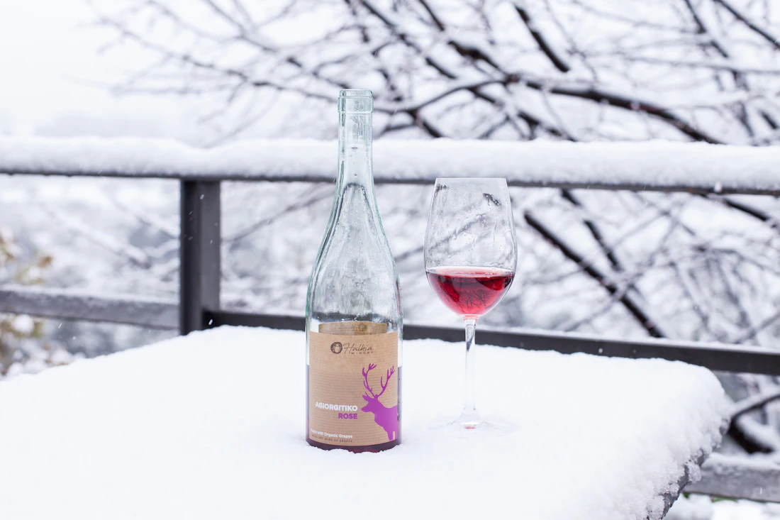 Fles en glas wijn in de sneeuw