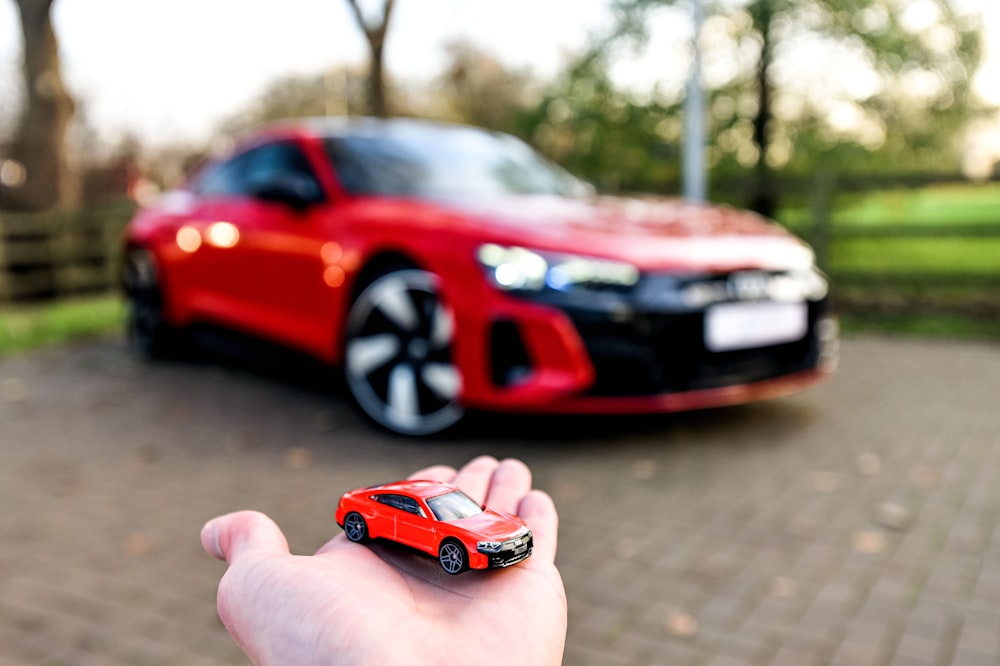 Una mano sosteniendo un coche de juguete