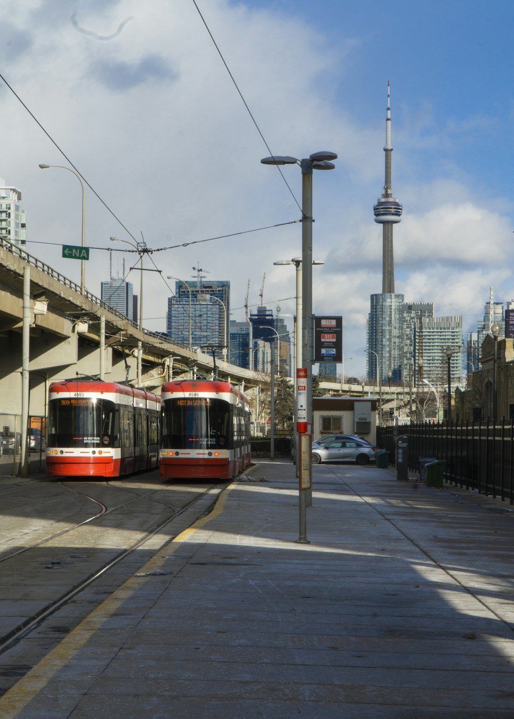 a couple of trolleys on a street with a city in the background