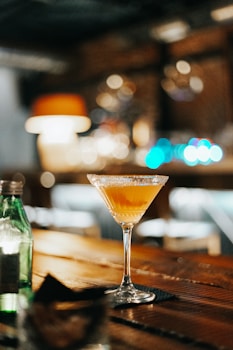 a glass of orange flavored soju on a table