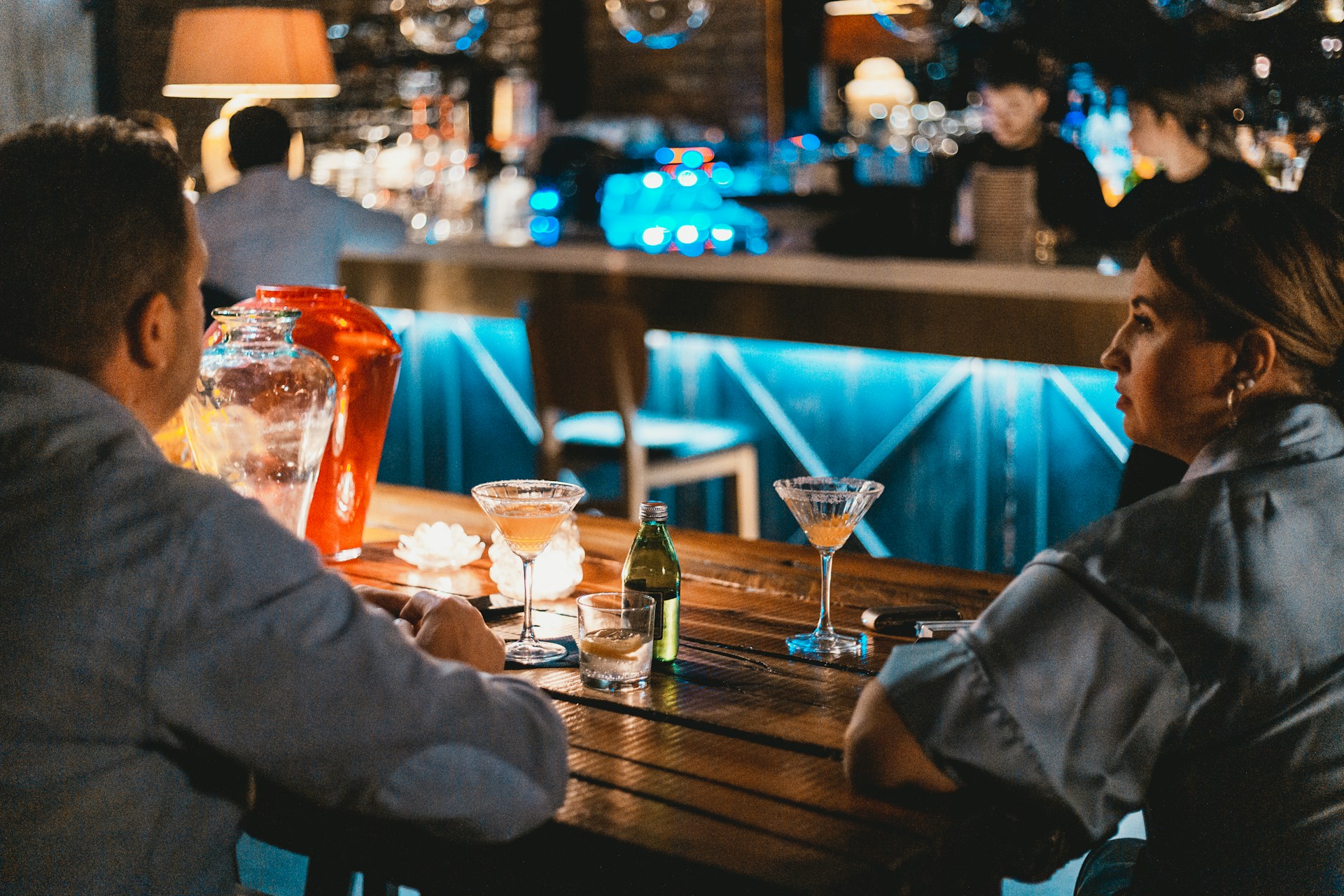 a man and woman sitting at a table with drinks