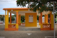 Wide shot of a large pavilion with newly painted exterior walls in soft pastel tones.