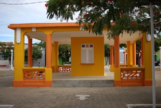 Wide shot of a large pavilion with newly painted exterior walls in soft pastel tones.