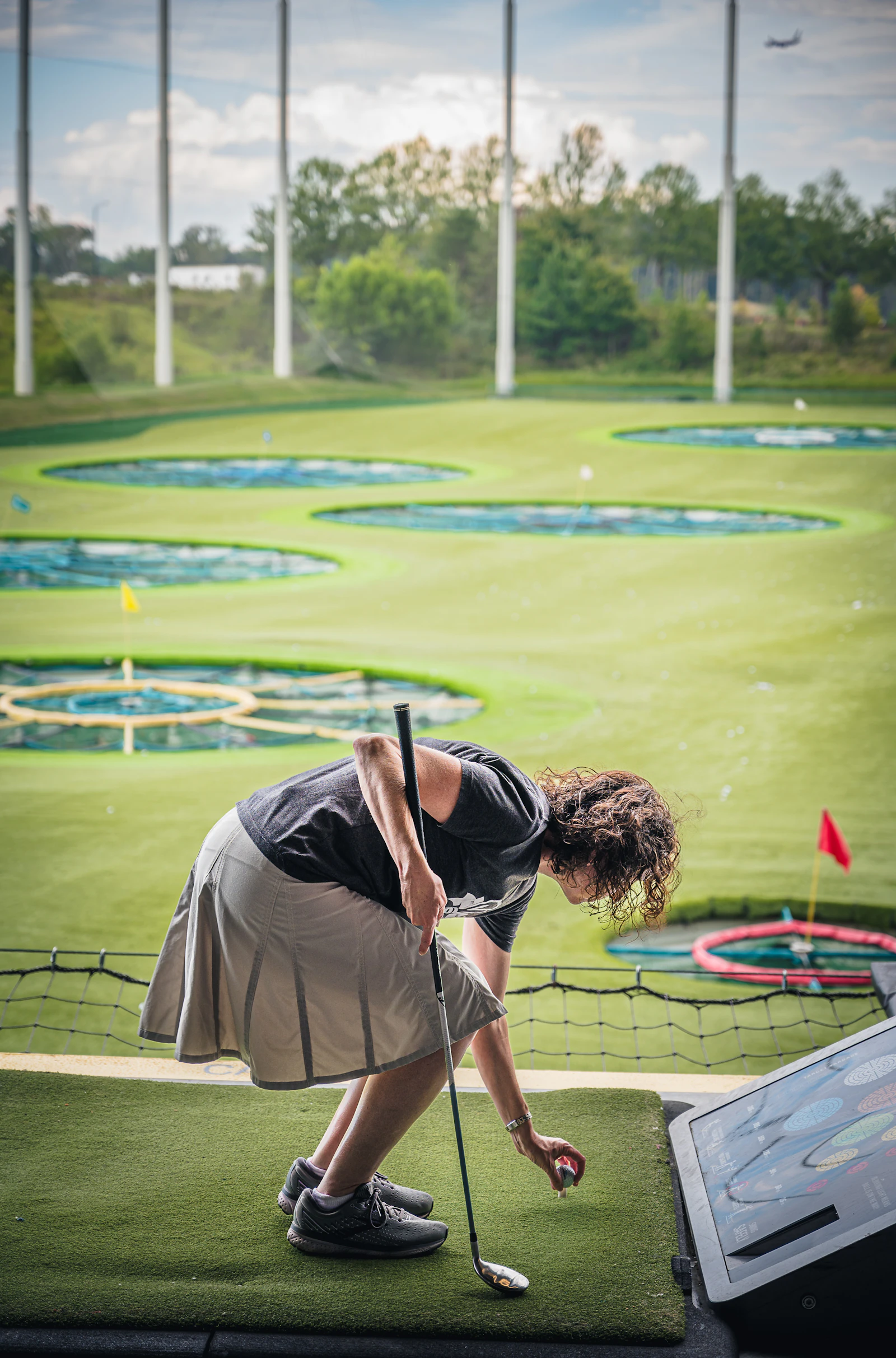 A golfer with a club on a tee, photographed in Charlotte, North Carolina