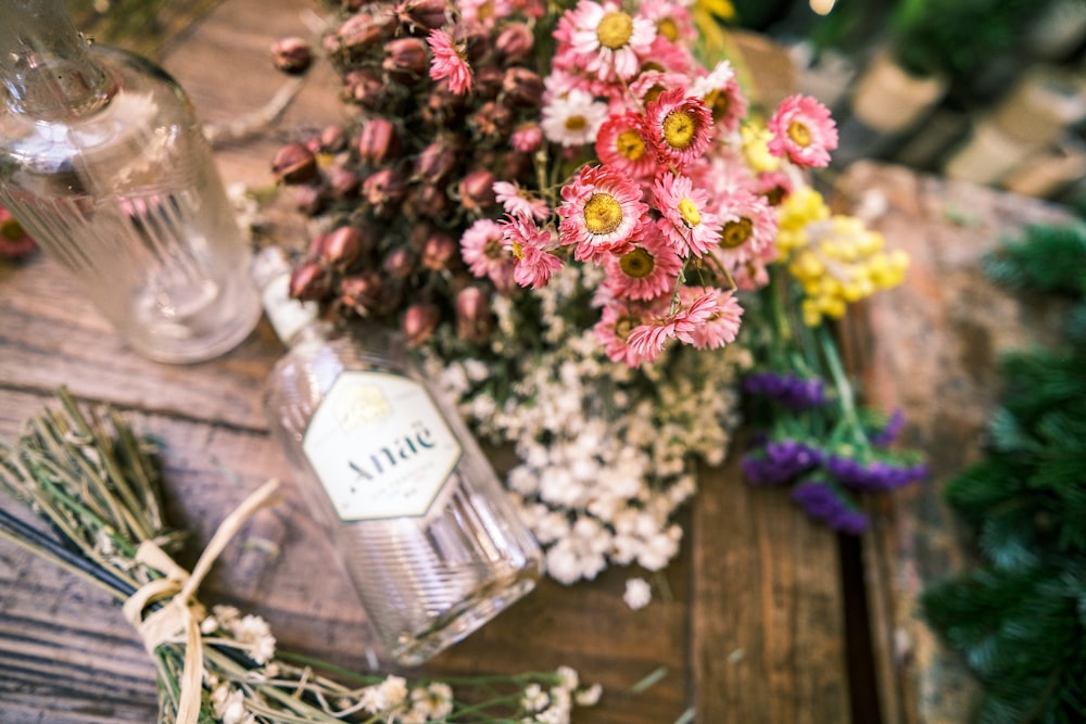 a bottle of water next to a bouquet of flowers