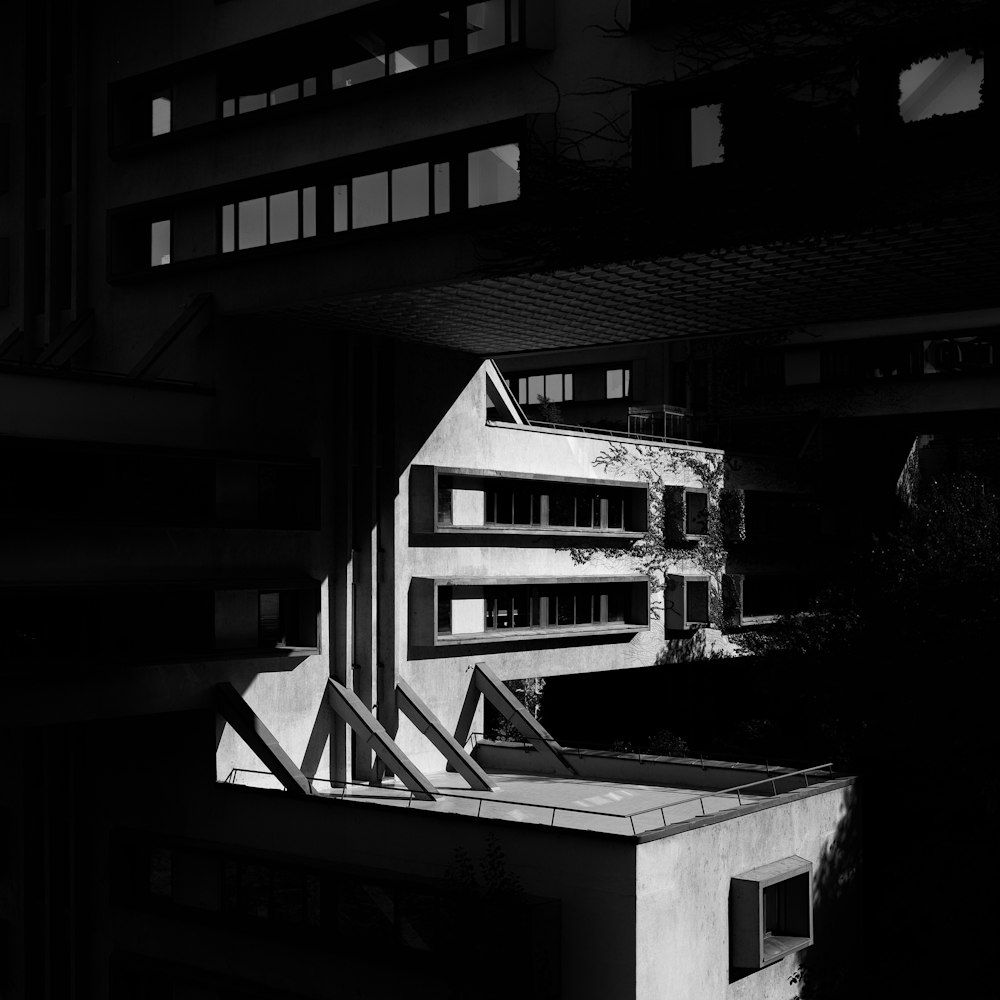 a black and white photo of a building with a large balcony