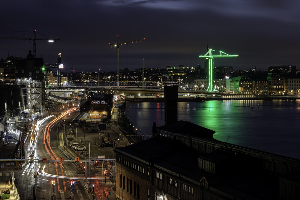 a bridge over a river with a green light at night