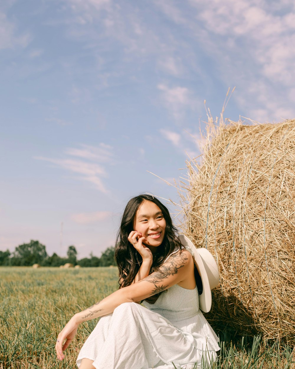 a woman sitting in a field of hay