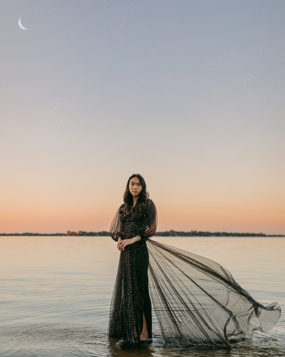 a person in a dress standing in water with a net in the hand
