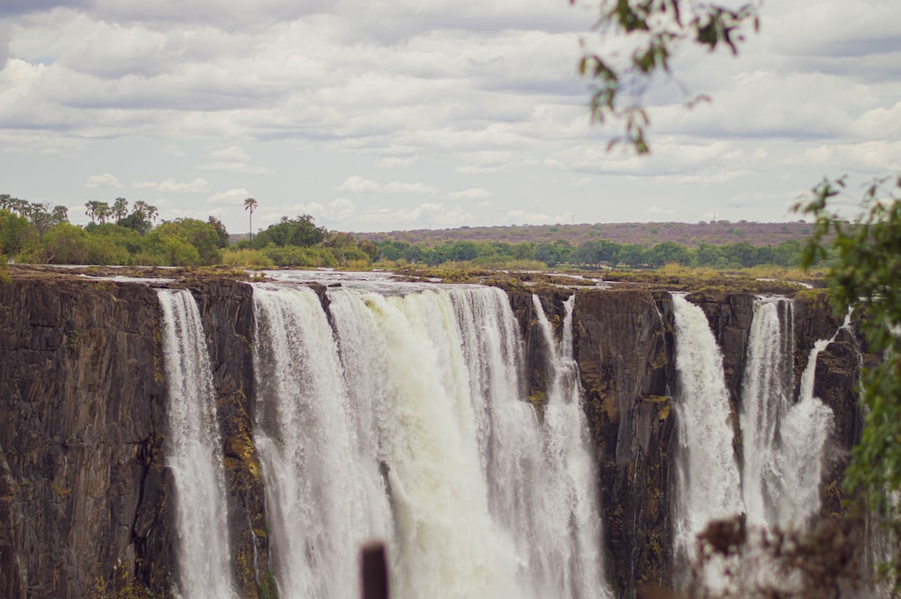 a large waterfall with trees in the background