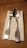 Close-up of a hand holding argentia’s sleek silverware clip against a soft linen tablecloth.