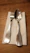 Close-up of a hand holding argentia’s sleek silverware clip against a soft linen tablecloth.