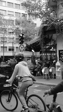 A candid photo of a bustling urban street with vibrant café life and parked cars.