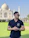 Smiling middle-aged man enjoying a sunny morning on a hotel balcony with the Taj Mahal in the background.