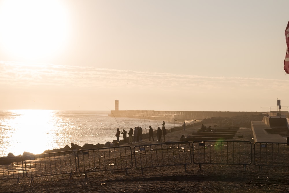 a group of people standing on a pier by the water