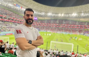 Happy customer wearing a Maxikits football jersey in a stadium.