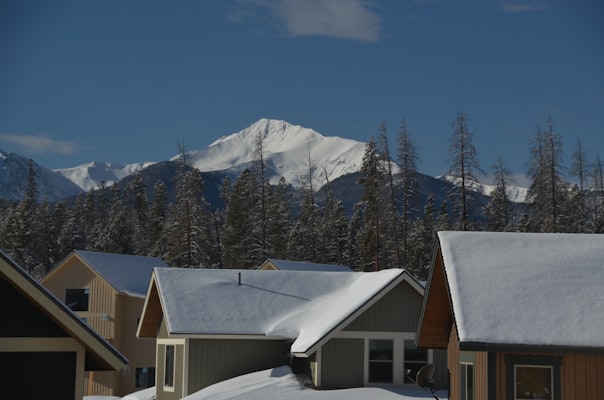 Snow-covered cabins in Winter Park village with peaks behind