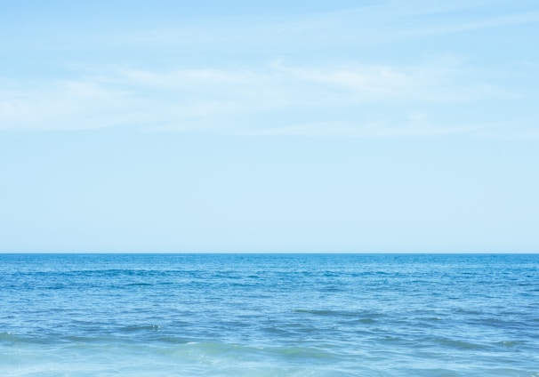 a body of water with a blue sky and clouds