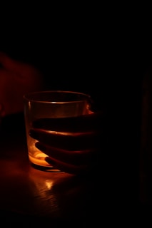 A vibrant glass of glowing juice illuminating a cozy evening setting.