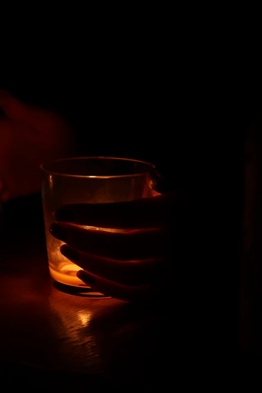 A close-up of a vibrant orange laser-engraved tumbler glowing under soft light.