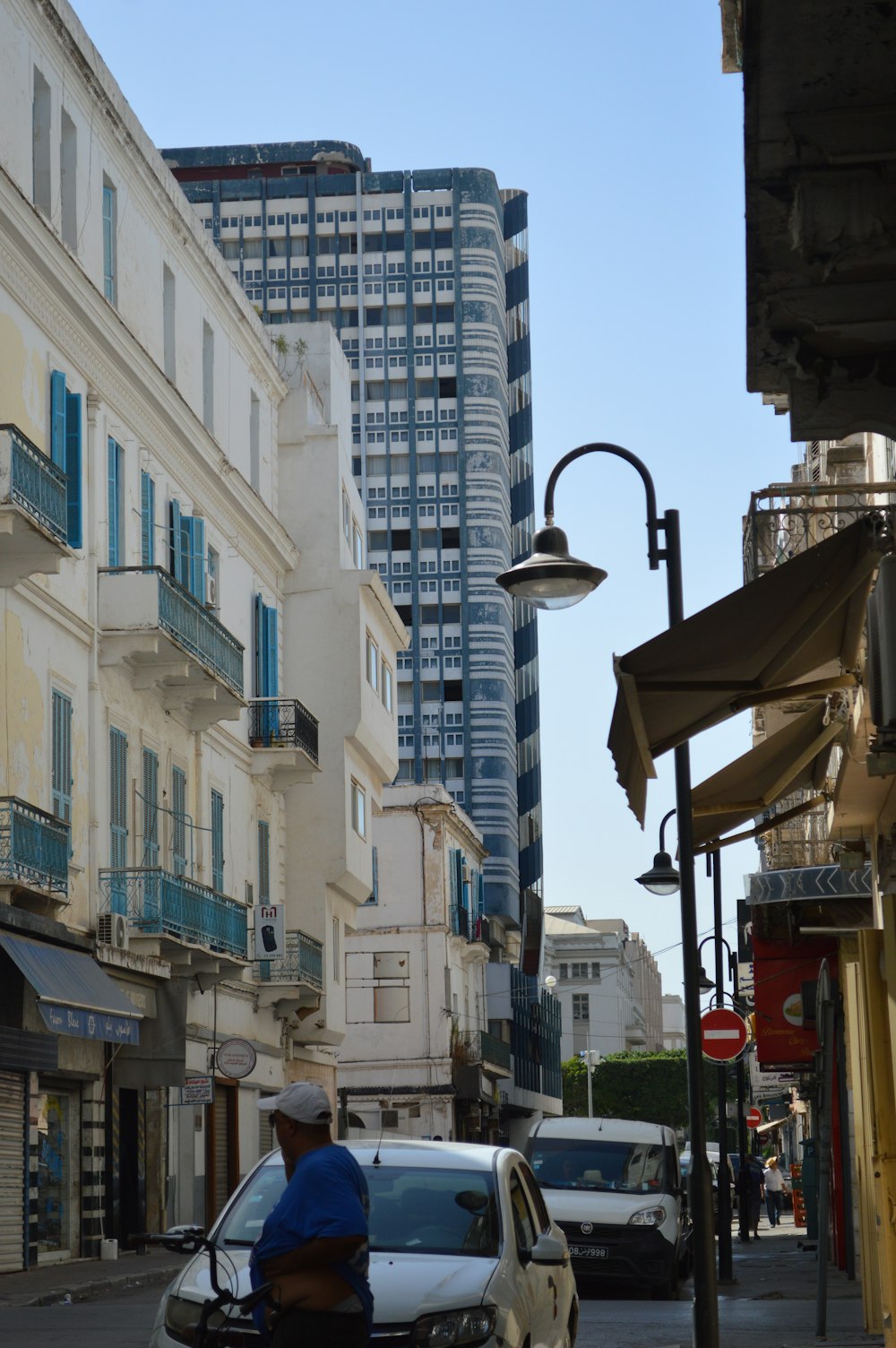 a person riding a bicycle down a street between buildings