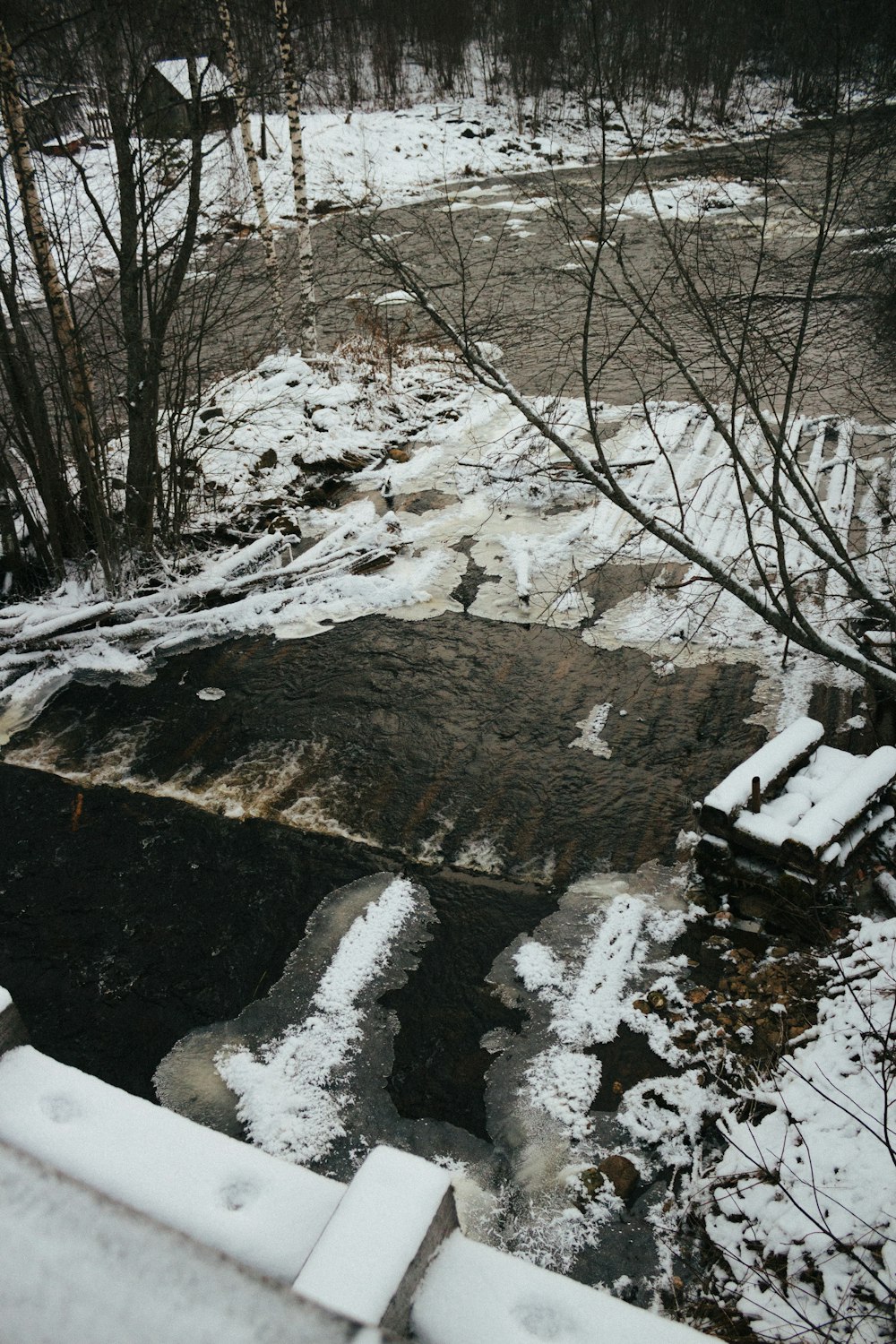 a stream with snow on the sides