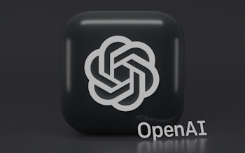 A 3D-style logo with a geometric design is prominently displayed on a dark, rounded square background. Below the logo, the word 'OpenAI' is written in a sleek, modern font.