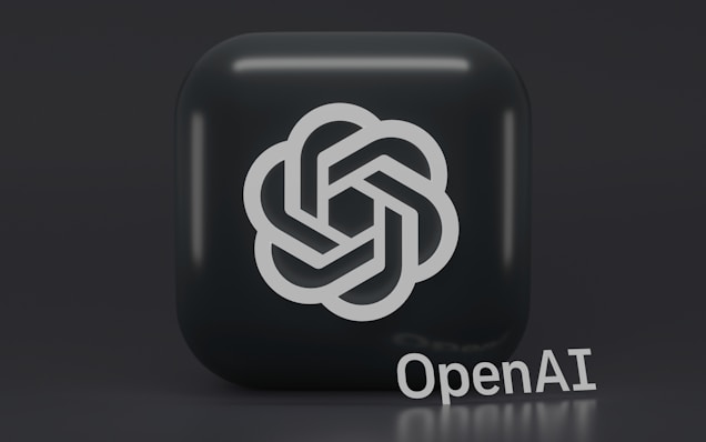 A 3D-style logo with a geometric design is prominently displayed on a dark, rounded square background. Below the logo, the word 'OpenAI' is written in a sleek, modern font.