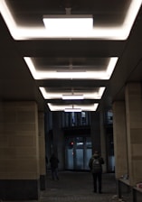 a man and woman walking through a hallway