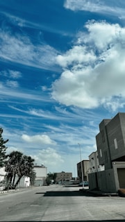 Modern residential buildings lined along a quiet suburban street under clear sky.