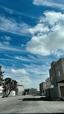 Modern residential buildings lined along a quiet suburban street under clear sky.